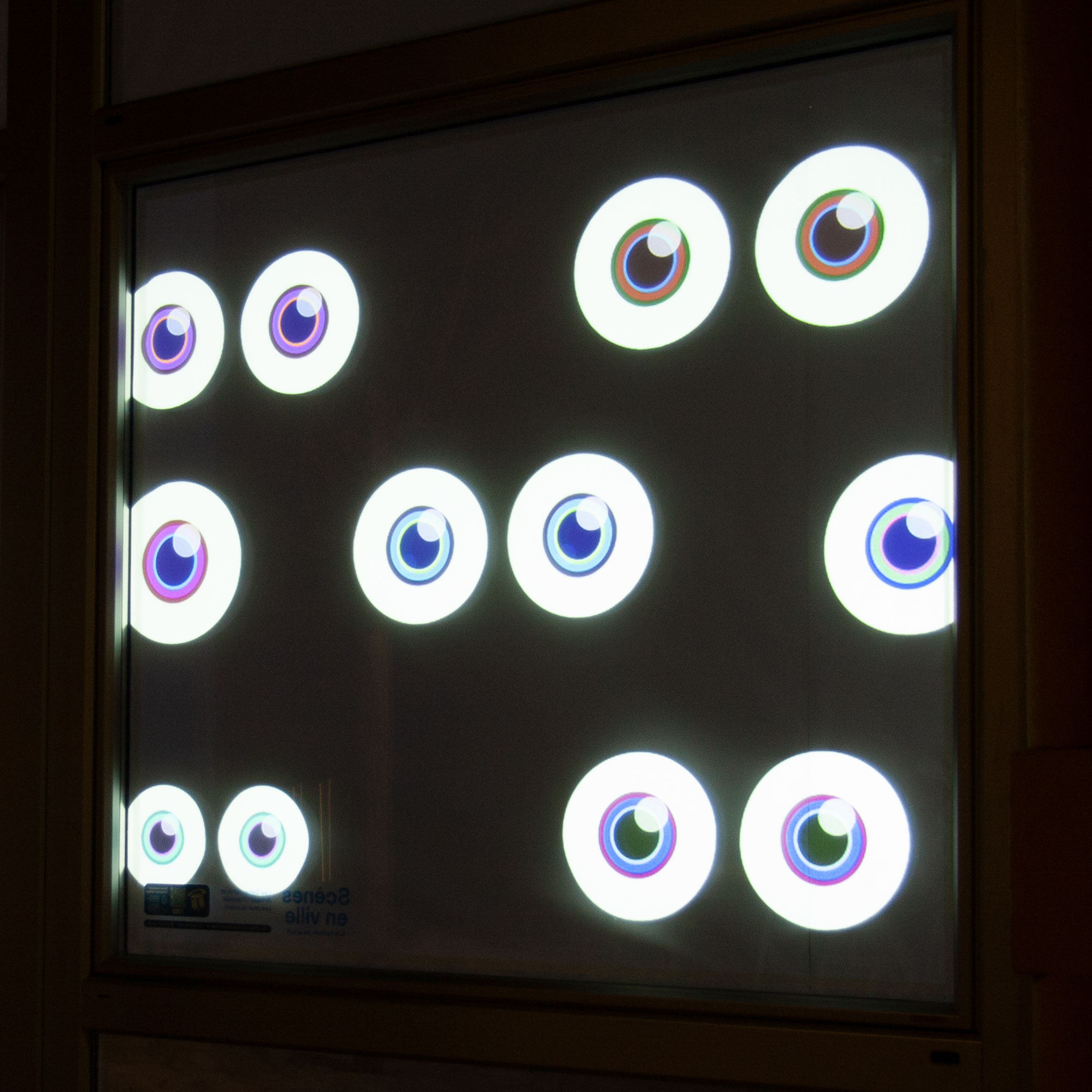 Vitrine animée par une projection vidéo représentant des yeux animés qui scrutent les passants.